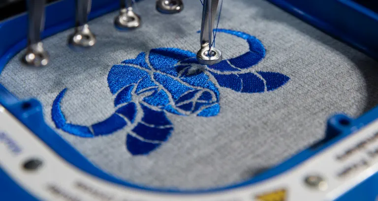 Broderie d'un logo sur machine à broder industrielle